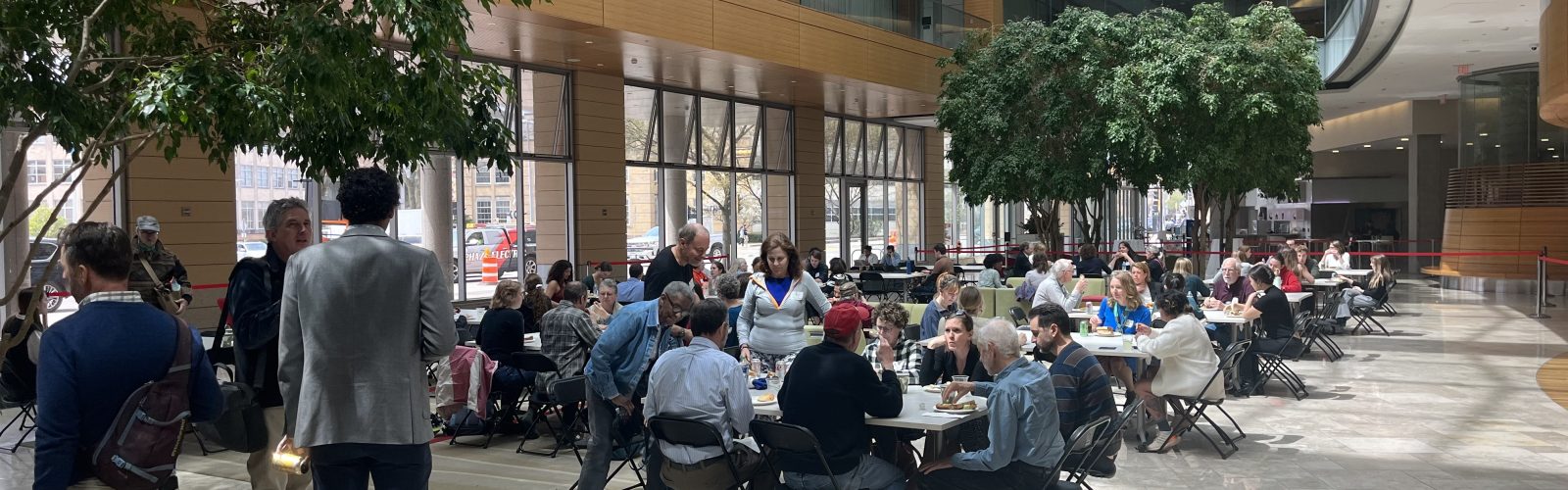 Photo of conference participants gathering for lunch in the atrium of the Discovery Building on the University of Wisconsin–Madison campus
