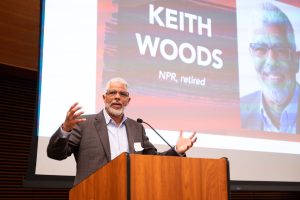 Keith Woods stands at a podium and delivers the 2025 conference keynote address