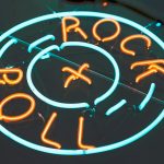 A neon sign reading "Rock + Roll."