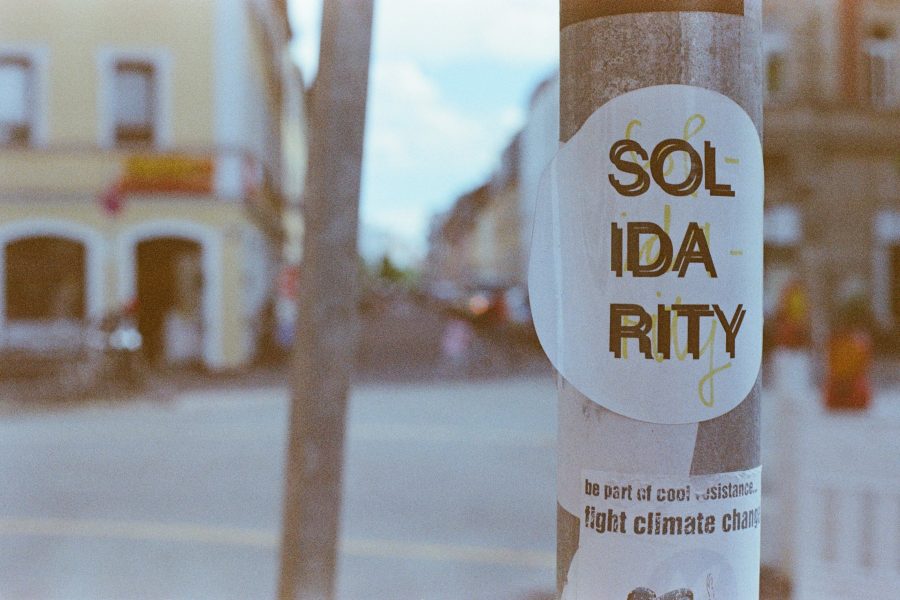 Photo of city street with a "Solidarity" sticker shown on a pole in the foreground